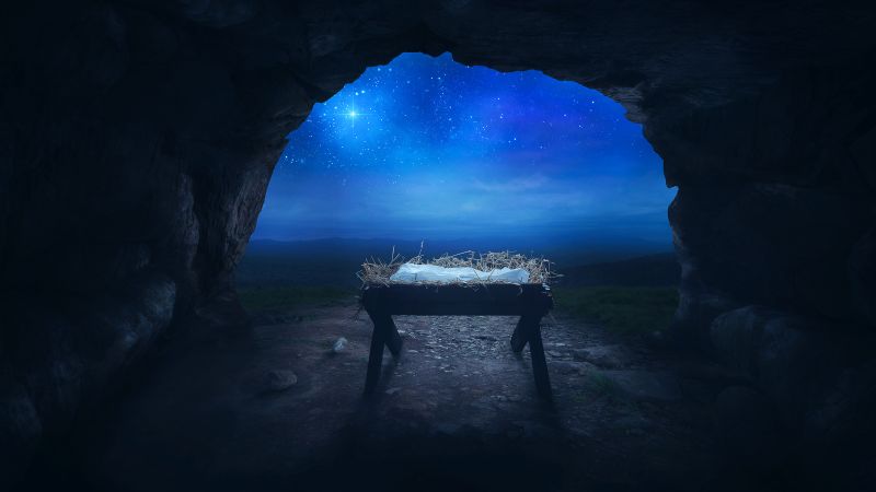manger with baby jesus in it in a cave with star in the sky