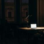 رجل مشغول وحده في مكتب مظلم ليلا مع الكمبيوتر