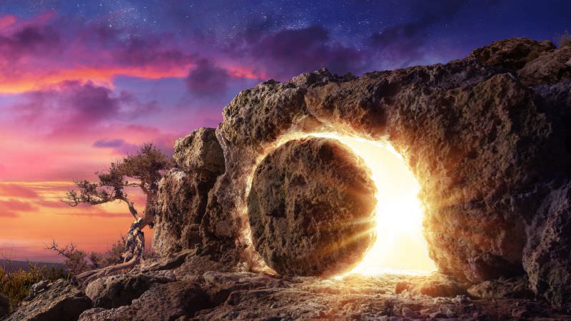 Rock being rolled from the entrance of a cave with light behind it representing Christ rising from the dead