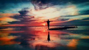 woman on beach at sunrise with bright colors