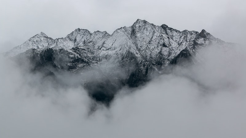 mountain peaks seen through gray clouds