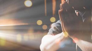 Religious young man praying to God in the morning