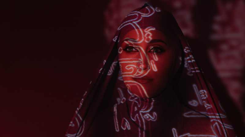 امرأة عربية في ضوء أحمر مع كتابة فوقها