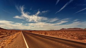 a long empty road in the middle of the desert