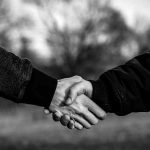 two men shaking hand in black and white photo