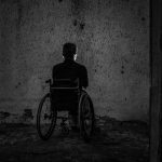 man in a wheelchair in a dark room