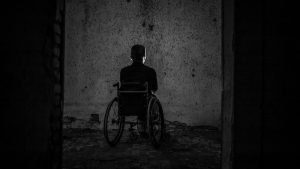 man in a wheelchair in a dark room