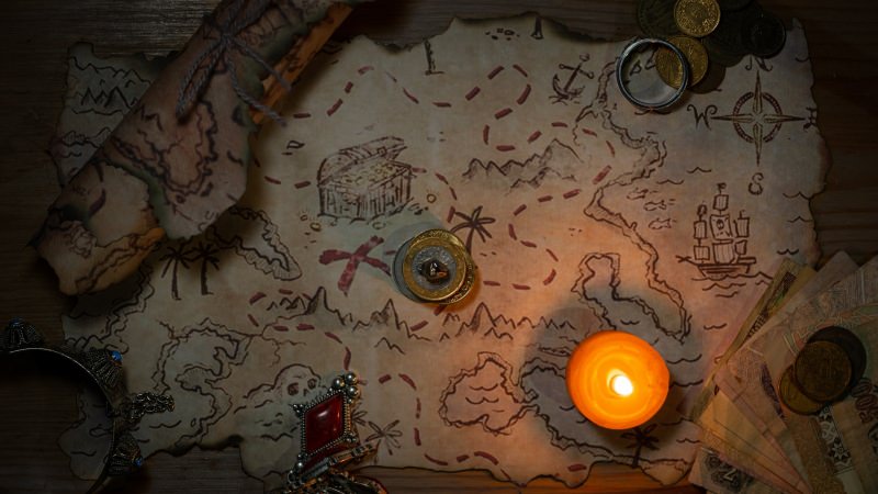 candle on a map with ship and treasure